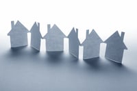 close up of houses cut out of paper on white background